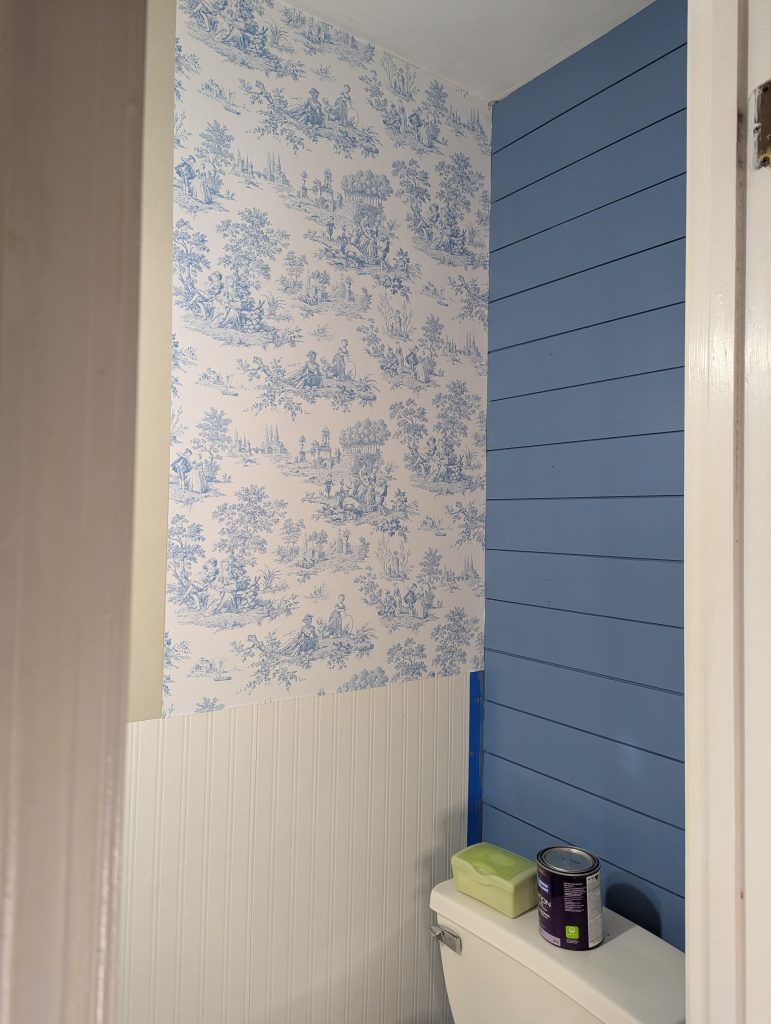 Installing the blue toilet peel and stick wallpaper 