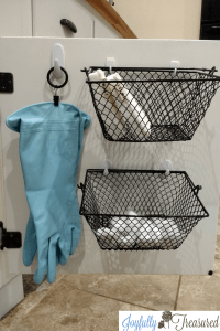 Ideas for organizing under the kitchen sink. Curtain ring clip and command hooks used to hang dish washing gloves. Command hooks and dollar tree baskets used to store sponges and dish washing tablets.