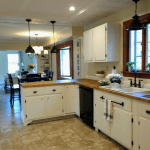 Farmhouse kitchen remodel on a budget with painted white cabinets, butcher block countertops, recessed and pendant lighting and oil rubbed bronze bridge faucet. Lots of budget remodeling ideas and inspiration. #kitchenremodel #farmhouse