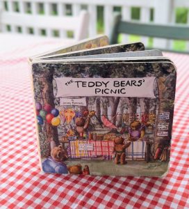 Teddy Bear Picnic board book displayed on a red gingham tablecloth, styled for a vintage-inspired birthday party theme.