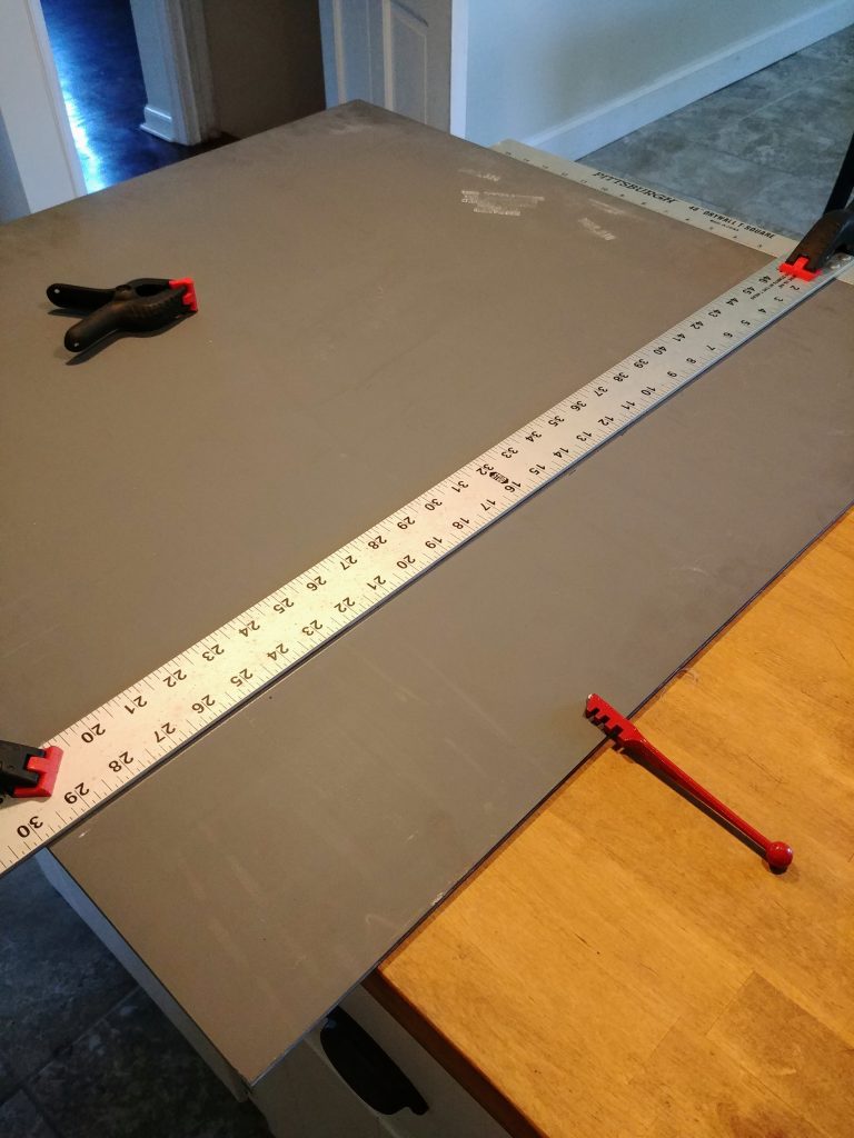 Cutting a sheet mirror with a glass cutting tool, DIY industrial farmhouse bathroom mirror with corner L brackets for a $100 bathroom makeover. We took our 1960s powder room and updated it to farmhouse style with just a $100 budget. Lots of great ideas for budget bathroom decor. #budgetdecor #homediy #bathroomdecor #farmhousedecor #farmhousestyle #bathroomideas #rustic
