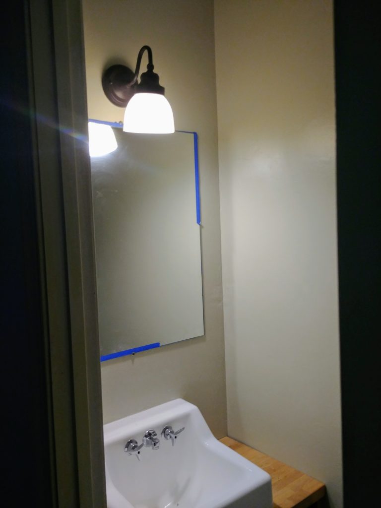 Making an Industrial farmhouse bathroom mirror with corner L brackets for a $100 bathroom makeover. We took our 1960s powder room and updated it to farmhouse style with just a $100 budget. Lots of great ideas for budget bathroom decor. #budgetdecor #homediy #bathroomdecor #farmhousedecor #farmhousestyle #bathroomideas #rustic