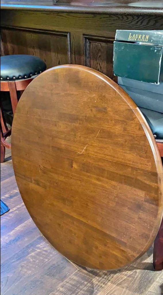 Reclaimed wood tabletop repurposed from a free online find, paired with a black metal base for a budget-friendly furniture makeover.