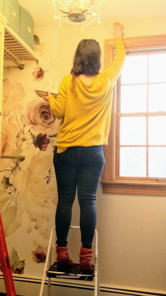 applying wallpaper glue for a DIY wallpaper accent wall