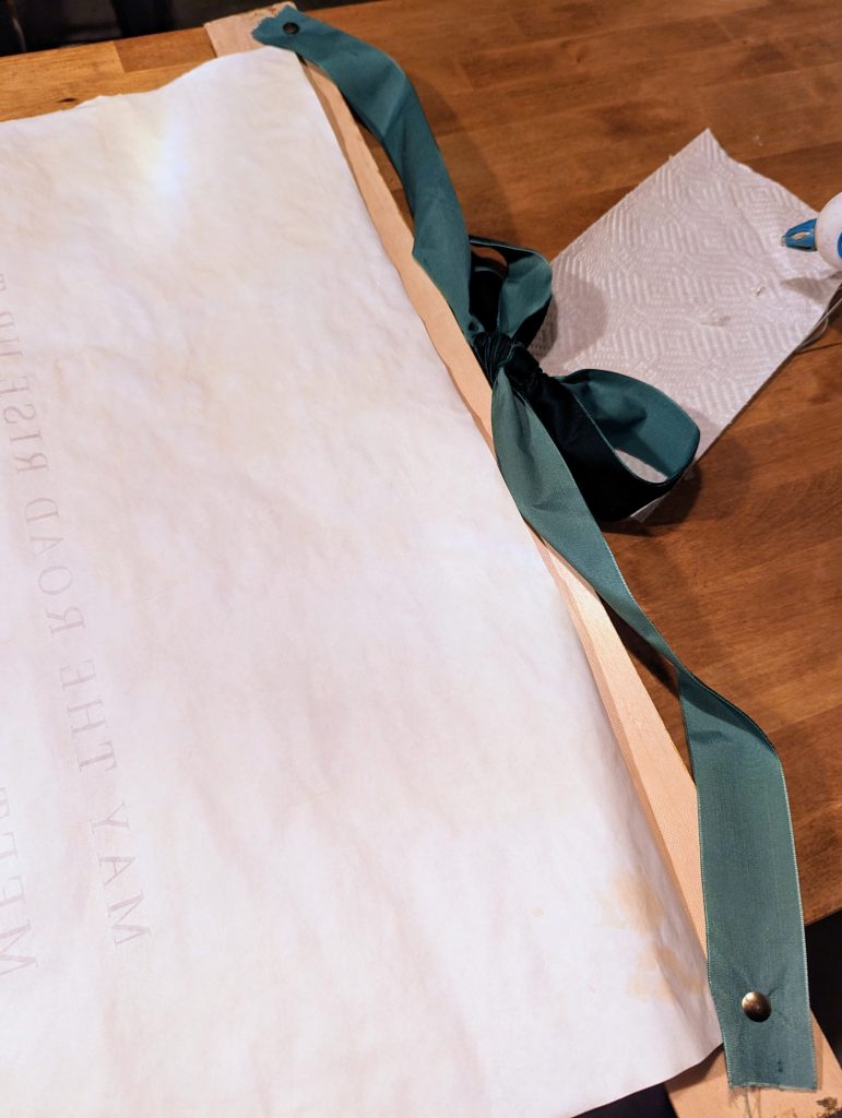 diy poster hanger with velvet ribbon, attaching the ribbon hanger to the frame.