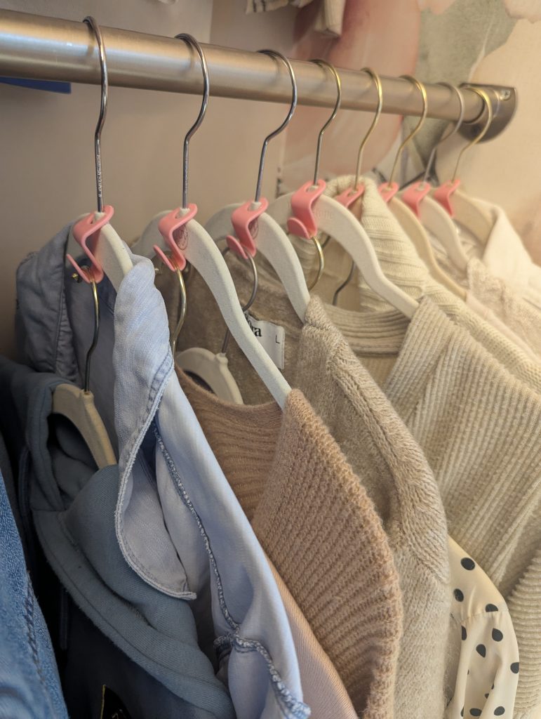 Closet with space-saving hanger hooks used in a row to organize clothes vertically; affordable closet organization idea under $10.